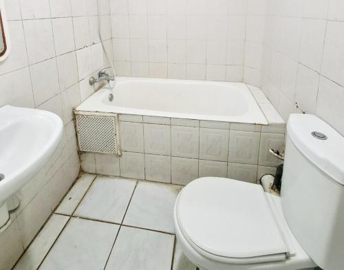 Un baño blanco con inodoro y bañera. en Camera Agadir, en Agadir