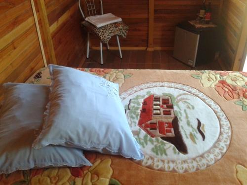 Una cama con dos almohadas y una manta. en Pousada Caverna Rio dos Bugres, en Urubici
