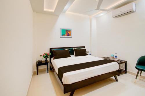 a bedroom with a bed and a chair in it at Hotel O Giriraj Palace by Govindam in Jaipur