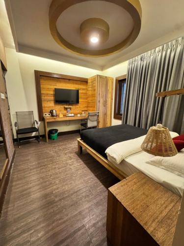 a bedroom with a bed and a desk and a television at La plaza in Pātan
