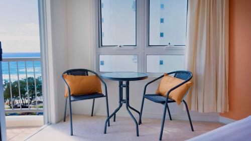 two chairs and a table in a room with a window at Studio Bliss by the Sea in Gold Coast
