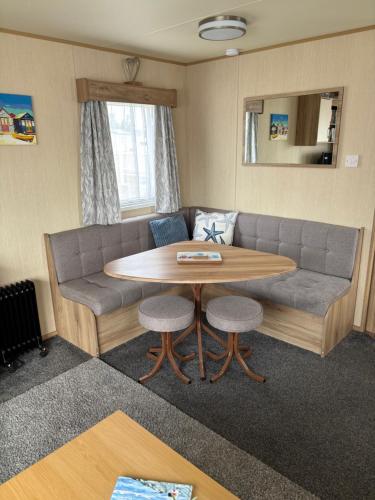 a living room with a table and a couch at 27 Ivy Close in Mablethorpe