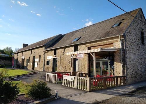 a small brick building with a fence in front of it at L'Eleganzia Piscines et nature en Normandie in Litteau