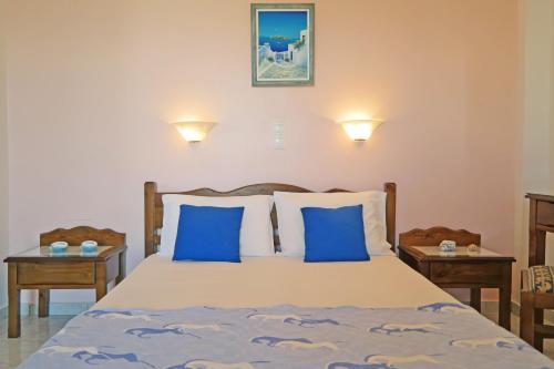 アギオス・プロコピオスにあるMina's Studios in Naxos Islandのベッドルーム1室(青い枕とテーブル2台付)