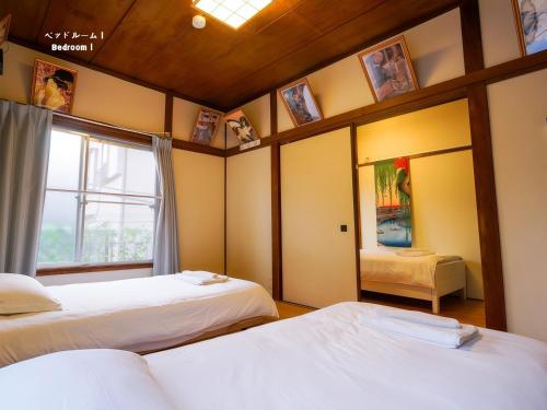 a room with two beds and a window at 7時IN19時OUT # 池袋王子赤羽駅無料送迎# 上野駅14分 # 日暮里駅10分 # 一棟貸切 # 最大7名 # B # 7 00 IN19 00 OUT # Free pick up Ikebukuro Oji and Akabane Stations # 14 min to Ueno # 10 min to Nippori # Whole house rental # Max 7 # B in Tokyo