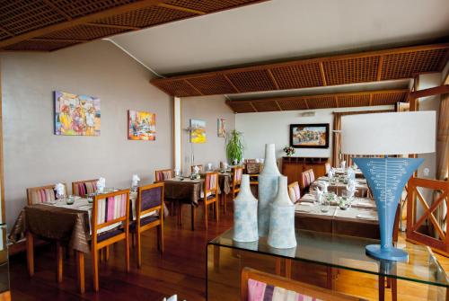 a restaurant with tables and chairs and a blue lamp at Palissandre ANTANANARIVO in Antananarivo