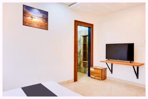 une chambre avec une télévision au mur et un lit dans l'établissement Hotel Ayodhya Rama-yana Palace Near Ramjanam Bhumi - Onsite Parking & Free Wifi Facilities - Fully-Air-Conditioned Rooms - Best Hotel In Ayodhya Book Quickly, à Ayodhya