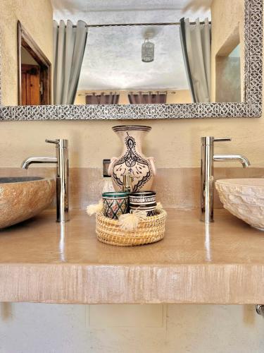 a bathroom with two sinks and a vase on a counter at Riad Maj Nia House in Essaouira