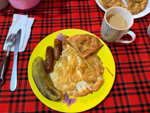Oloitokitok にあるGreenfield Homestay -Full boardのソーセージとパイが乗った黄色い皿