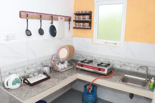 una cocina con fregadero y encimera con utensilios en Aluth Gedara Villa, en Talpe