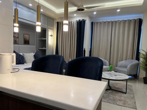 a living room with blue chairs and a table at Skyline Hotel Apartments-Elysium Tower Facing Centaurus Mall Islamabad in Islamabad
