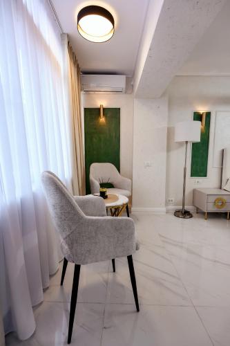 a living room with a chair and a table at Luxury House in Drăgăşani