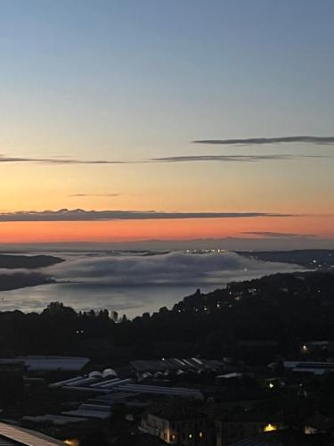 a sunset view of a city and the ocean at Casa Patrone in Nebbiuno