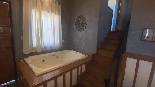 a bathroom with a bath tub and a staircase at Chalés Lavras de Minas - Belém in Ouro Preto