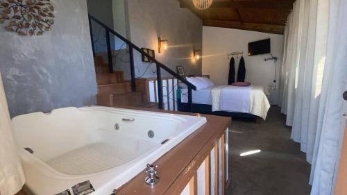 a large bath tub in a room with a bedroom at Chalés Lavras de Minas - Belém in Lavras Novas
