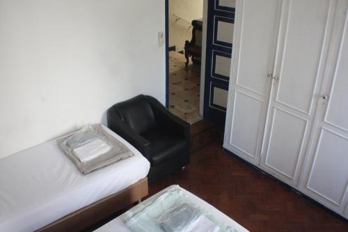 a room with a couch and a chair and a door at Farfalla Guest House in Rio de Janeiro