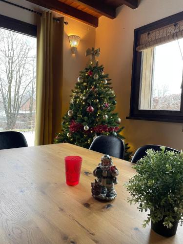 a christmas tree in a room with a wooden table at Gîte La Borbotte in Malmedy