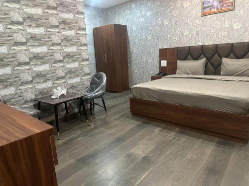 チャンディーガルにあるHotel dream landのベッドとテーブルと机のある寝室