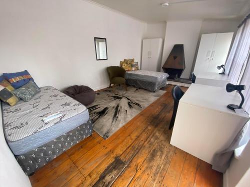 a living room with a bed and a refrigerator at 1 Cora Terrace Accommodation in Gqeberha