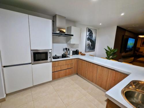 a kitchen with white cabinets and a sink in it at Skyline Hotel Apartments-Elysium Tower Facing Centaurus Mall Islamabad in Islamabad