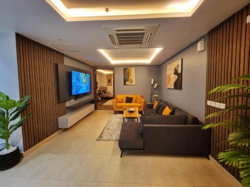 a living room with a couch and a flat screen tv at Skyline Hotel Apartments-Elysium Tower Facing Centaurus Mall Islamabad in Islamabad