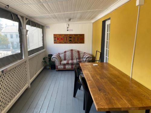 a dining room with a table and a couch at 1 Cora Terrace Accommodation in Gqeberha