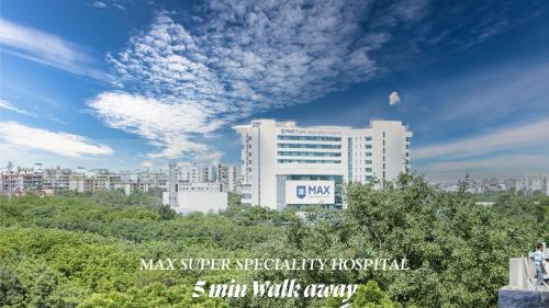 a large white building in a city with a sky at Hotel HomeAste 001 Near Yashobhoomi Convention Center in New Delhi