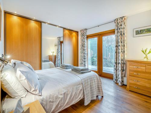 a bedroom with a large bed and a large window at Shore House in Kilcreggan