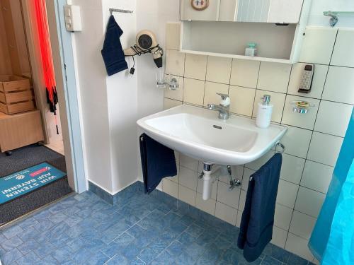 baño con lavabo blanco y azulejos azules en Chalet Gold, en Affoltern