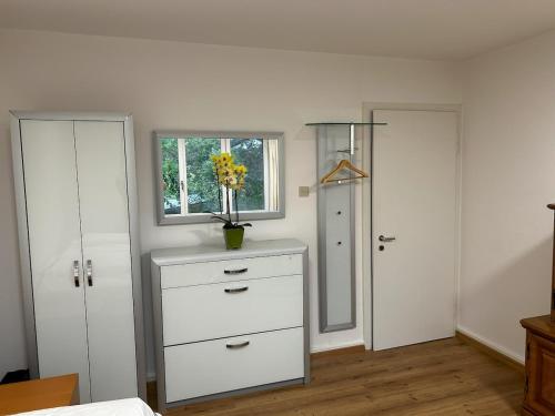 Un dormitorio con un tocador con un jarrón de flores. en Chalet Gold, en Affoltern