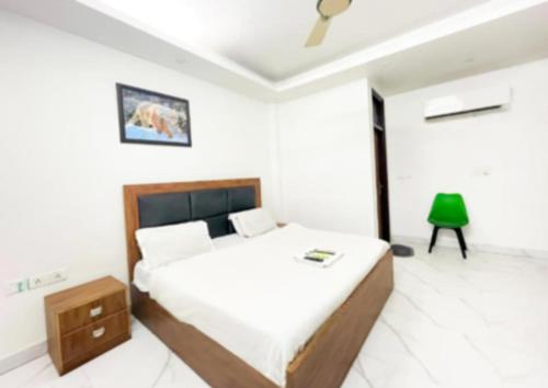 a white bedroom with a bed and a green lamp at Home Stay Near Nizamuddin Railway Station in New Delhi