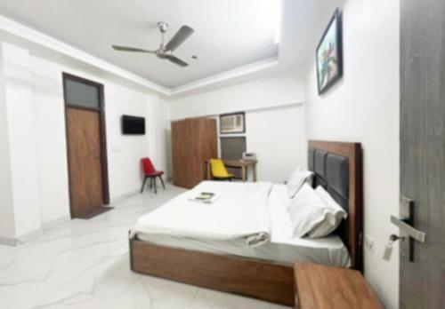 a bedroom with a bed and a room with a tv at Home Stay Near Nizamuddin Railway Station in New Delhi