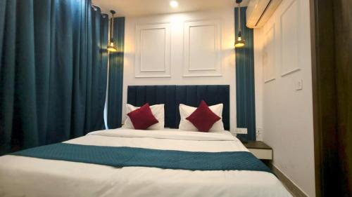 a bedroom with a bed with red pillows at Hotel HomeAste 001 Near Yashobhoomi Convention Center in New Delhi