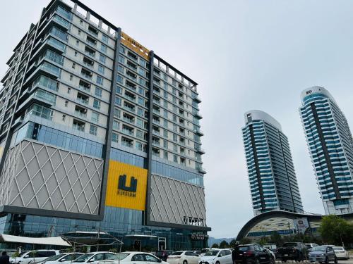 a large building with cars parked in a parking lot at Skyline Hotel Apartments-Elysium Tower Facing Centaurus Mall Islamabad in Islamabad