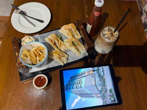 a table with food and a tablet on a table at Skyline Hotel Apartments-Elysium Tower Facing Centaurus Mall Islamabad in Islamabad