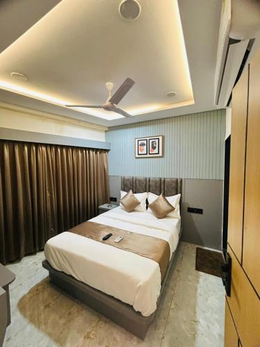 a bedroom with a large bed with a ceiling at Hotel sun town in Ahmedabad