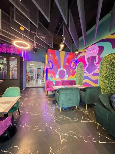 a room with tables and chairs and a colorful wall at Skyline Hotel Apartments-Elysium Tower Facing Centaurus Mall Islamabad in Islamabad