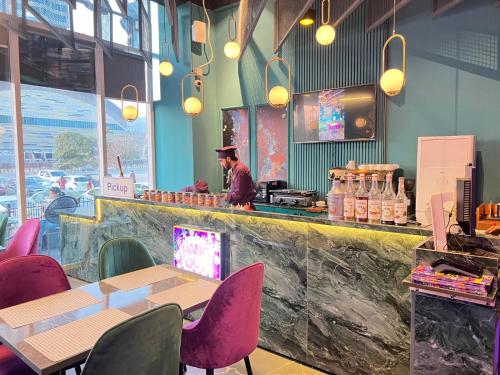 a man standing at the counter of a restaurant at Skyline Hotel Apartments-Elysium Tower Facing Centaurus Mall Islamabad in Islamabad