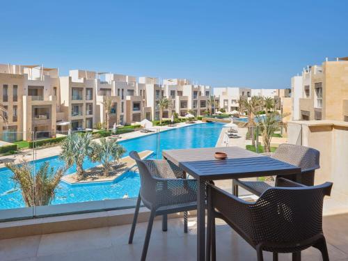 a table and chairs on a balcony with a swimming pool at Boutique Residence Mangroovy-Lemon Spaces Gouna in Hurghada