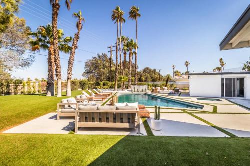 a backyard with a swimming pool and palm trees at Architectural Villa for Groups 16 Pax in Palm Springs