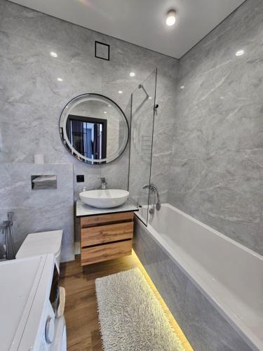 Un baño con lavabo, bañera y espejo. en Яровиця 41, en Lutsk