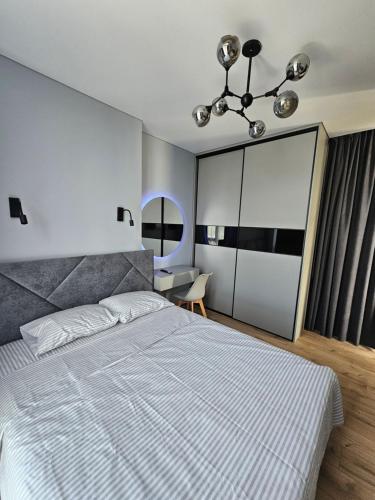Un dormitorio con una gran cama blanca y un escritorio. en Яровиця 41, en Lutsk