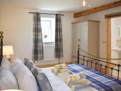 a bedroom with a bed with two pillows on it at Stabal Eithinog in Pen-y-groes