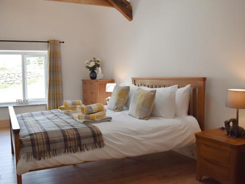 a bedroom with a bed with white sheets and pillows at Stabal Eithinog in Pen-y-groes