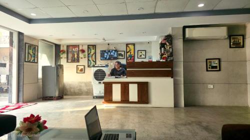 a woman sitting at a counter in a lobby at Hotel HomeAste 001 Near Yashobhoomi Convention Center in New Delhi