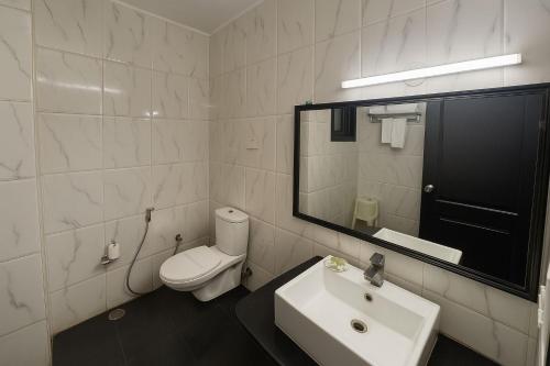 a bathroom with a sink and a toilet and a mirror at Hotel Perfect, Karol Bagh, 2 mins walk from metro station in New Delhi