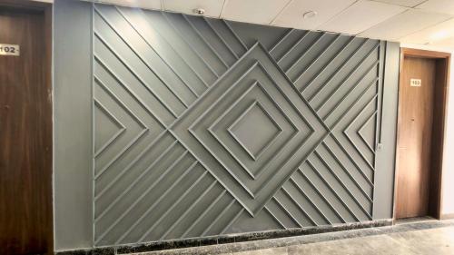 a metal wall with a geometric design on it at Hotel HomeAste 001 Near Yashobhoomi Convention Center in New Delhi
