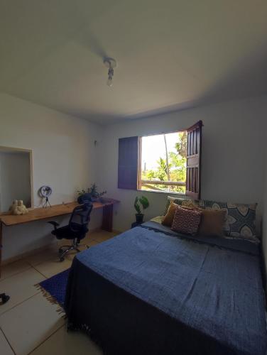 イタカレにあるCasa Vista Mar - Iemanjáのベッドと机と窓のある寝室