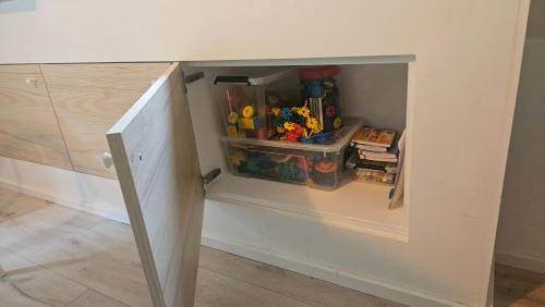a cabinet with a door open with toys in it at De Bosdriehoek III in Durbuy