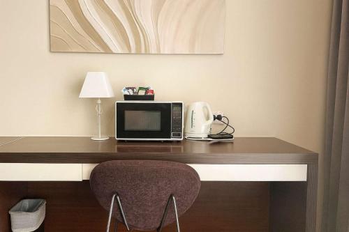 a room with a desk with a microwave and a chair at L20 High Apt 2 Beds in Gold Coast